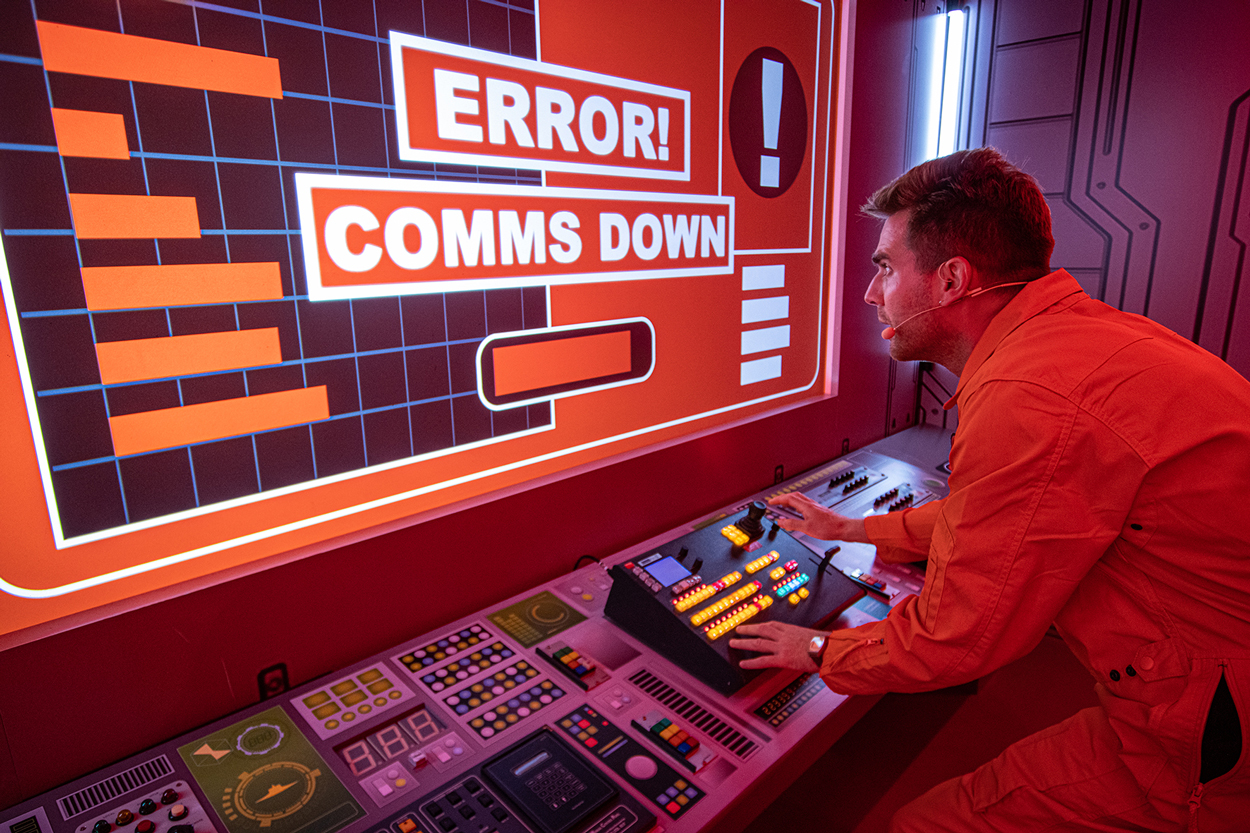 A man in a jumpsuit interacting with a screen